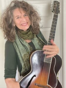 Photo of Cyd Smith holding a guitar